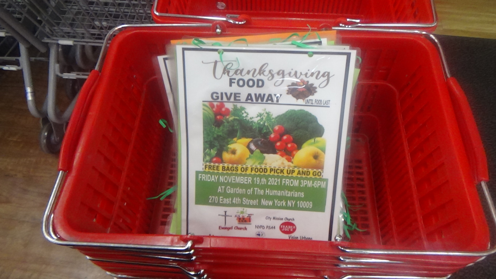 Red basket holding flyers for a Thanksgiving food giveaway event